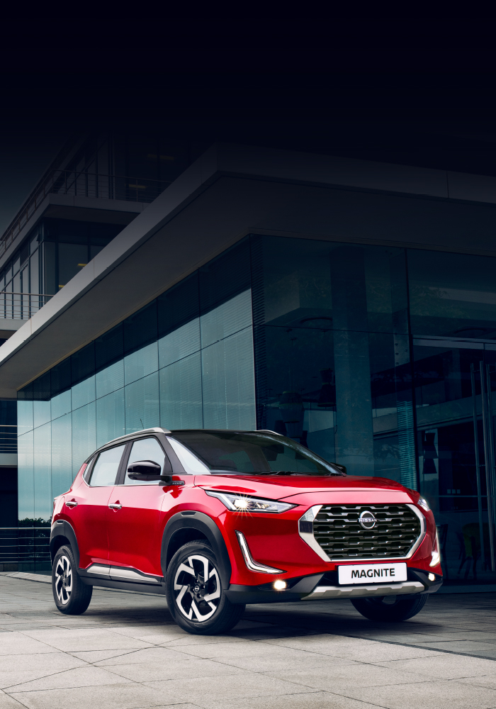 Red Nissan Magnite in front of building